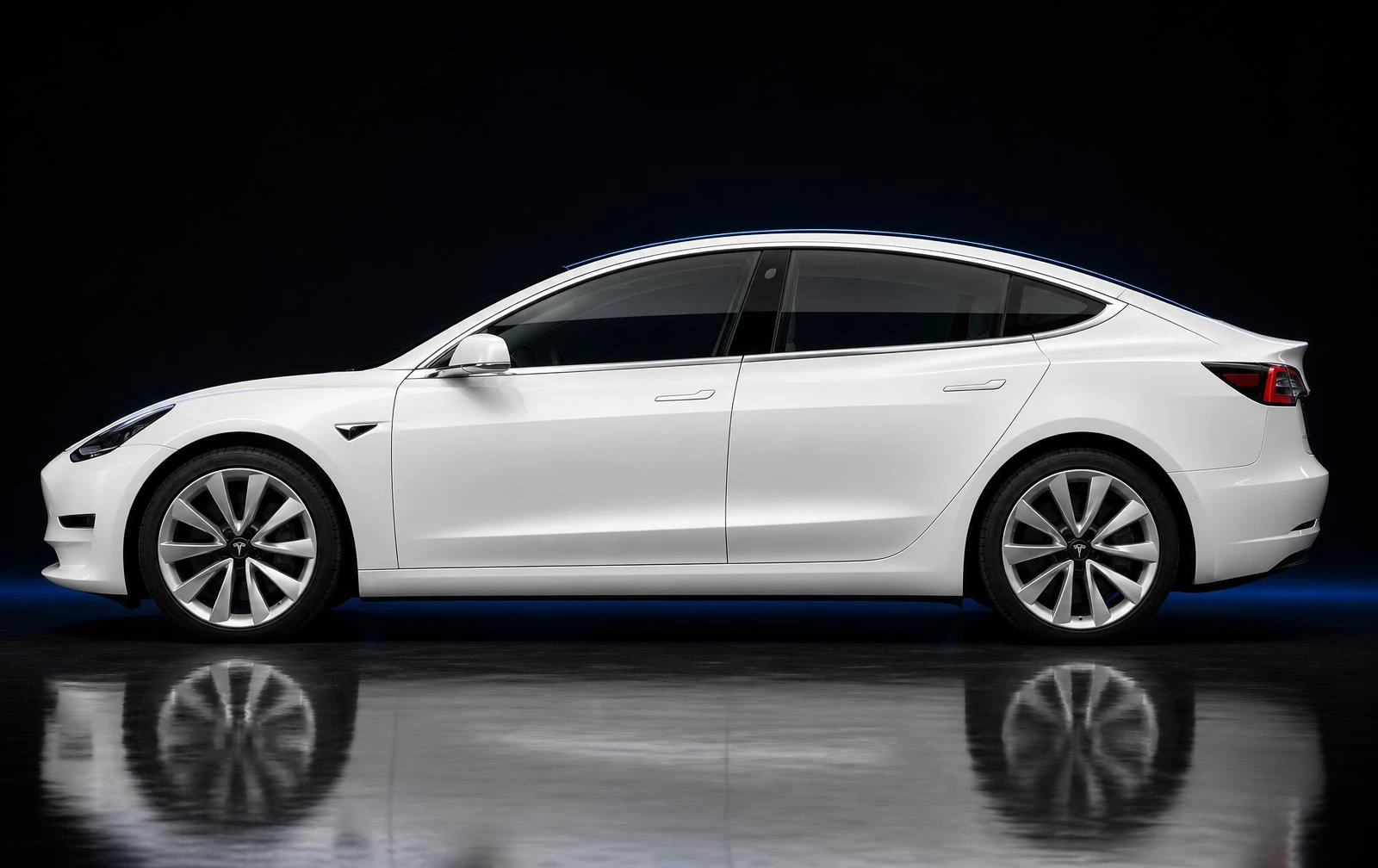 Side profile of a white Tesla Model 3 in a dark studio with bright factory chrome window surrounds and mirror cap
